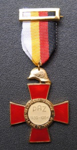 Medalla conmemorativa de los "25 Años de Paz" entregada a todos los excombatientes. En ella se puede leer la leyenda: "En la guerra tu sangre, en la paz tu trabajo".